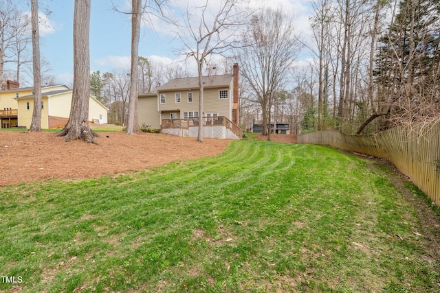 view of yard with a deck, stairway, and fence