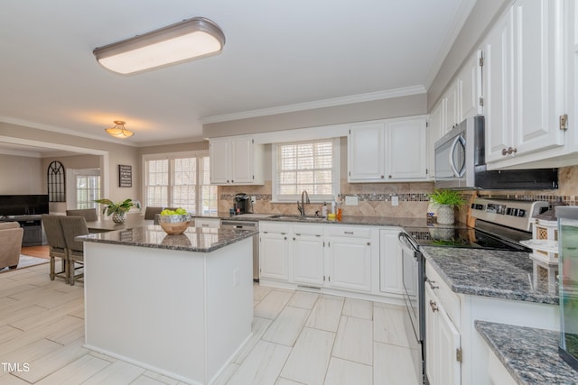 kitchen with white cabinetry, dark stone countertops, appliances with stainless steel finishes, and a sink