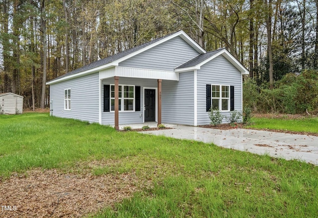 view of front of home featuring an outbuilding, a porch, a storage unit, and a front yard