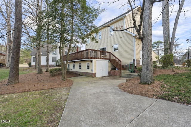 view of property exterior with stairway and a wooden deck