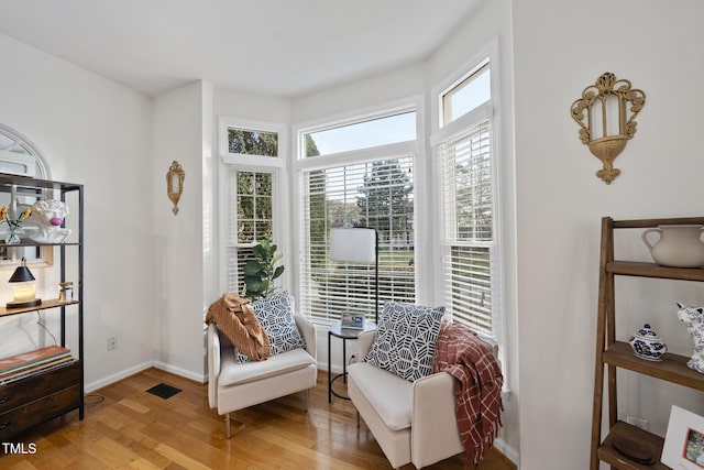 sitting room with visible vents, wood finished floors, and baseboards