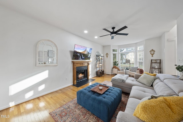 living area with a ceiling fan, baseboards, light wood-style flooring, a fireplace with flush hearth, and recessed lighting