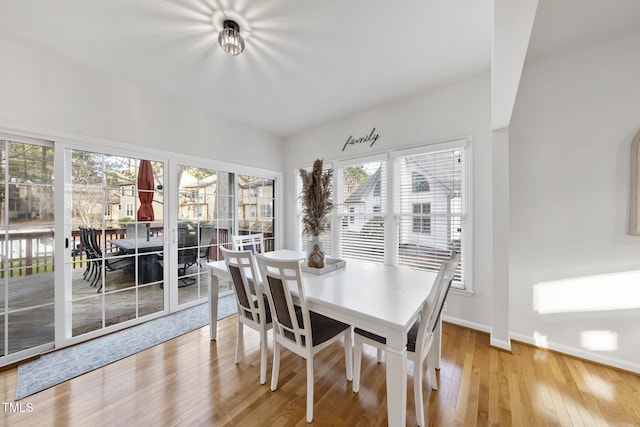 dining area with light wood-type flooring and baseboards