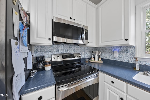 kitchen with dark countertops, white cabinets, and stainless steel appliances