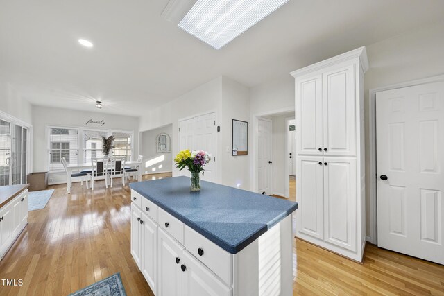 kitchen featuring dark countertops, light wood-style flooring, and white cabinetry