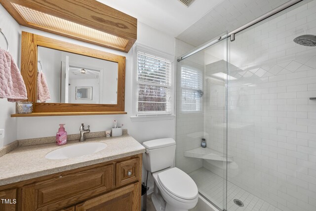 bathroom with vanity, toilet, and a shower stall