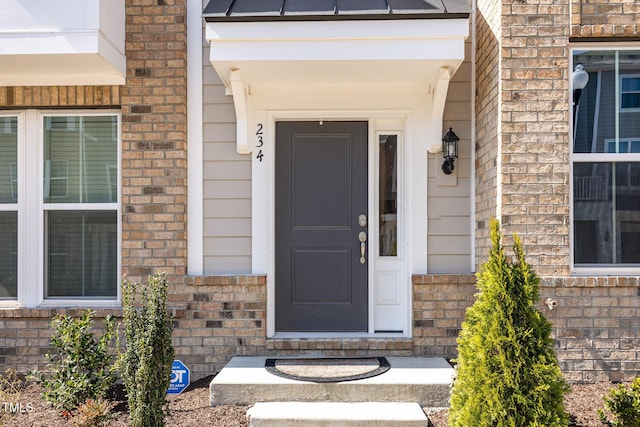 doorway to property featuring brick siding