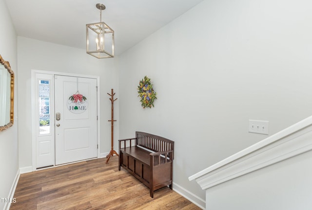 entryway featuring baseboards, a notable chandelier, and wood finished floors