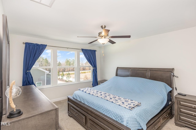 bedroom with visible vents, light colored carpet, baseboards, and a ceiling fan