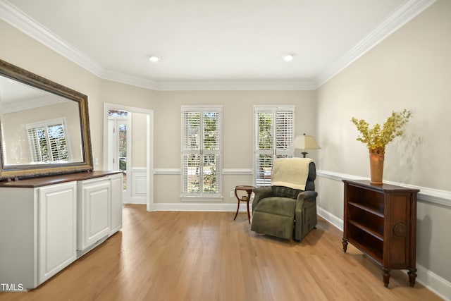 sitting room with crown molding, baseboards, and light wood-type flooring