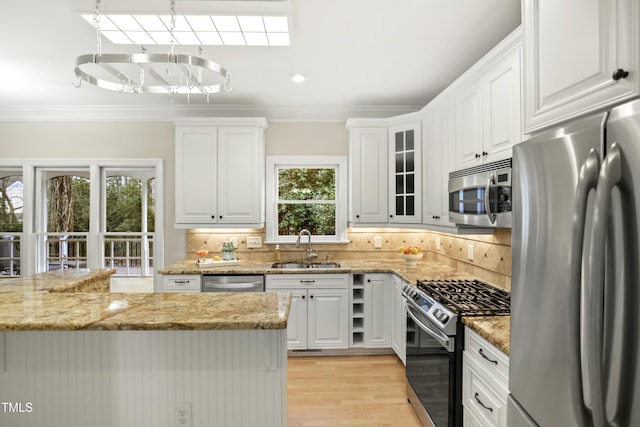 kitchen with backsplash, ornamental molding, stainless steel appliances, and a sink