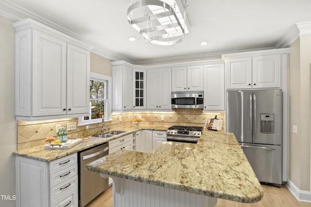 kitchen featuring light stone countertops, a sink, decorative backsplash, white cabinets, and appliances with stainless steel finishes