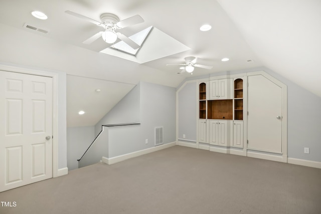 additional living space featuring visible vents, lofted ceiling with skylight, and carpet flooring