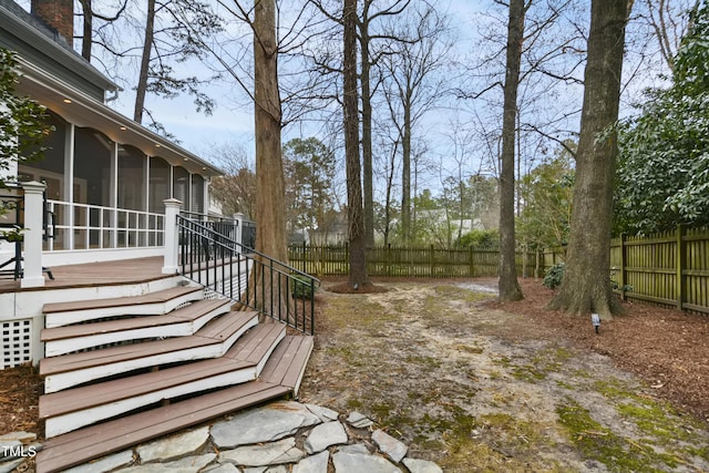 view of yard featuring stairway, fence, and a sunroom