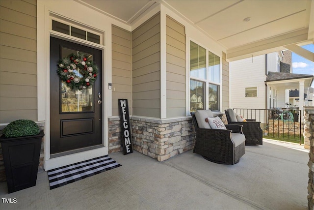 property entrance with a porch and stone siding