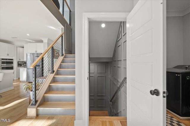 stairs featuring washer / dryer and wood finished floors