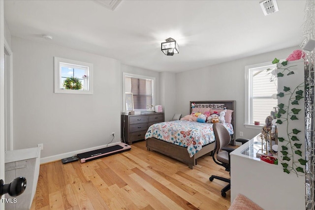 bedroom featuring visible vents, baseboards, and light wood finished floors