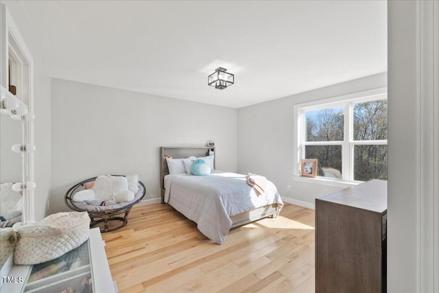 bedroom with light wood-style flooring and baseboards