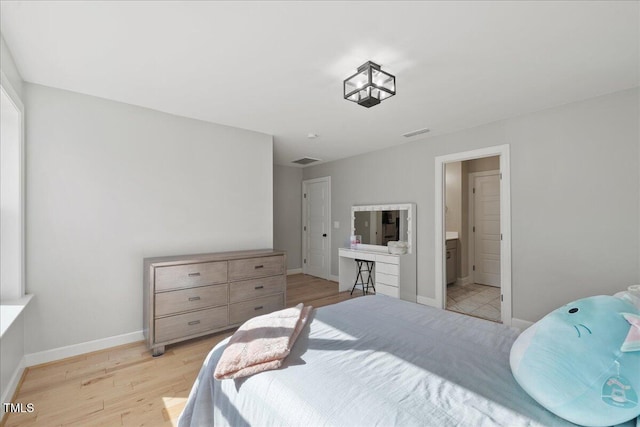 bedroom featuring visible vents, baseboards, and light wood-style floors