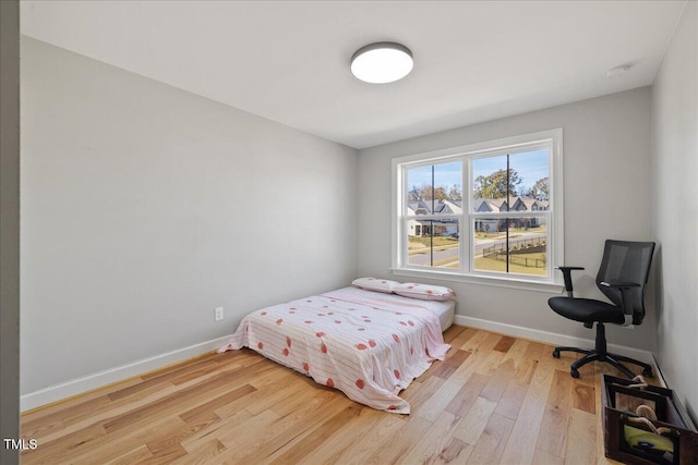 bedroom featuring light wood-style flooring and baseboards