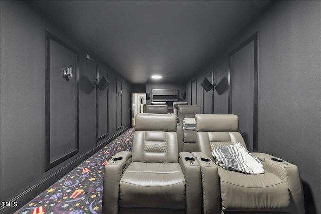 home theater room featuring a decorative wall and carpet floors