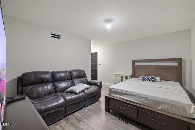 bedroom featuring visible vents, baseboards, and wood finished floors