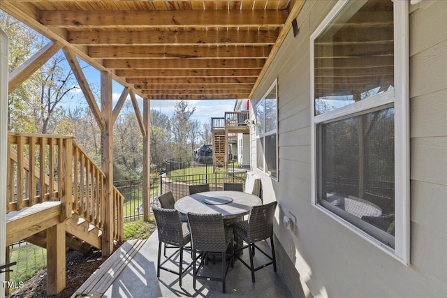 wooden terrace featuring outdoor dining space and stairway