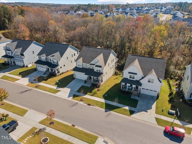 drone / aerial view with a residential view and a wooded view