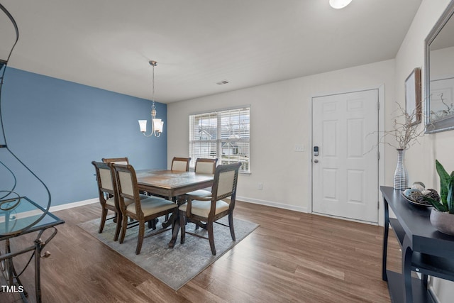 dining space featuring visible vents, baseboards, and wood finished floors