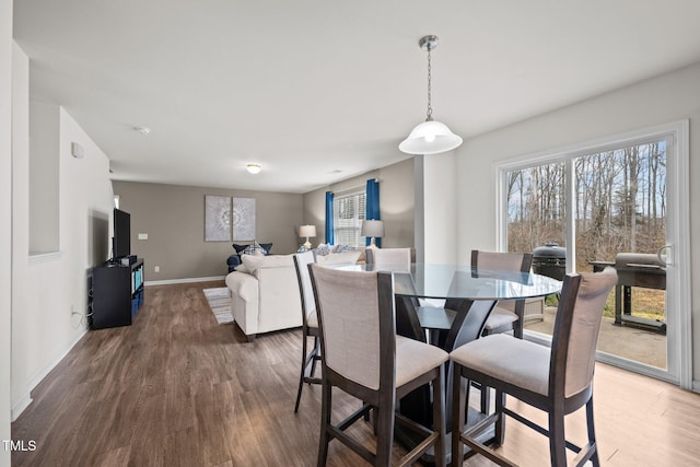 dining space with plenty of natural light, baseboards, and wood finished floors