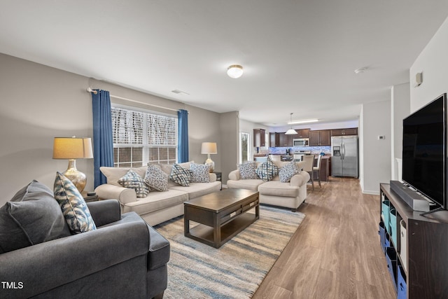 living room featuring visible vents and light wood-type flooring