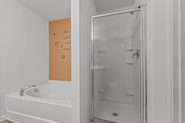 bathroom featuring a bath and a stall shower