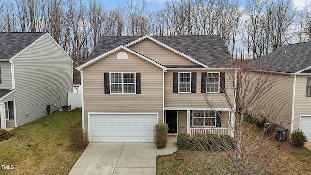 traditional home with a front yard, driveway, a porch, an attached garage, and a shingled roof