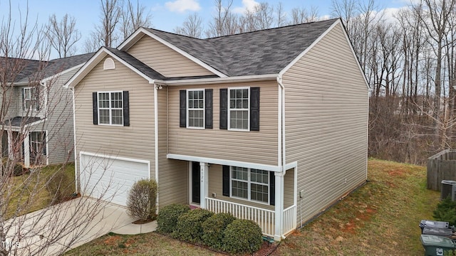 traditional-style home featuring covered porch, driveway, a shingled roof, and a garage