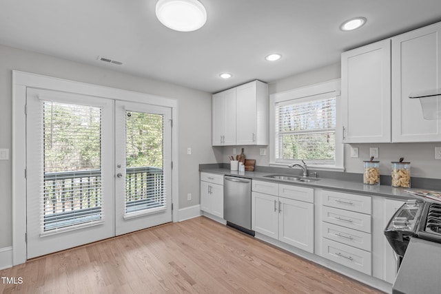 kitchen featuring a sink, visible vents, dishwasher, and white cabinets