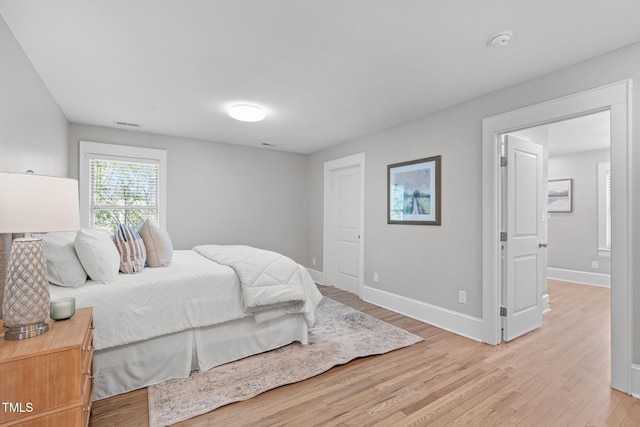 bedroom featuring baseboards and light wood finished floors