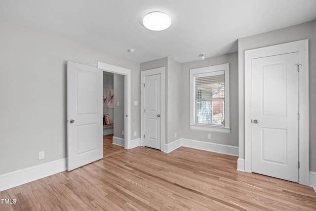 unfurnished bedroom featuring baseboards and light wood-style floors