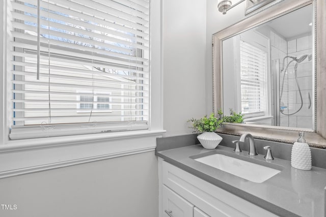 bathroom featuring a shower and vanity