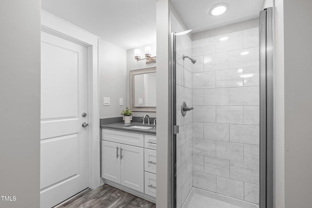 bathroom featuring vanity, a shower stall, and wood finished floors