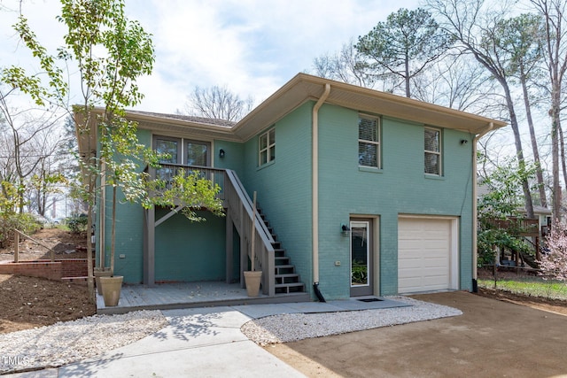 view of front of house with stairway, an attached garage, and concrete driveway