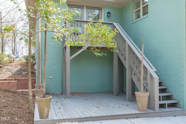 property entrance with a wooden deck and brick siding