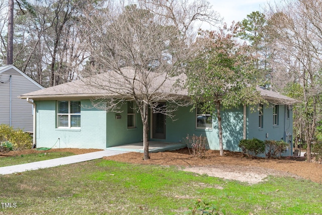 back of property with brick siding, an attached carport, and a lawn