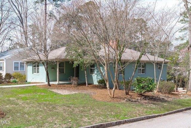 ranch-style home featuring brick siding, covered porch, and a front yard