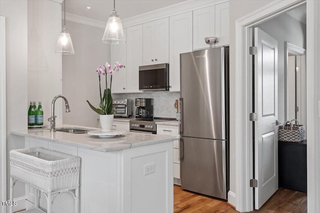 kitchen featuring tasteful backsplash, light wood-type flooring, white cabinets, stainless steel appliances, and a sink