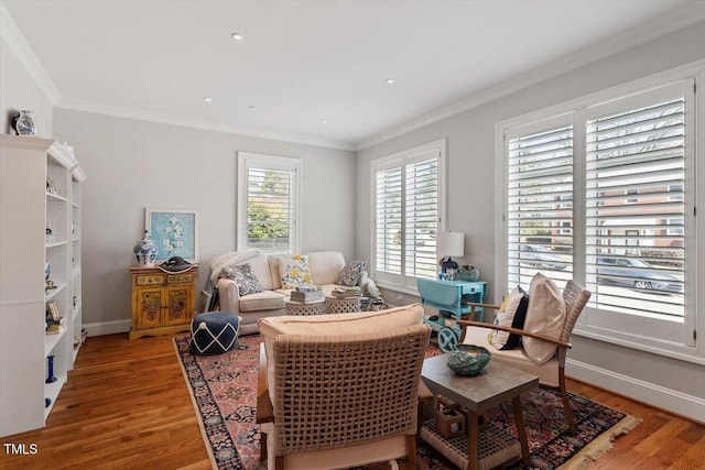 living area with light wood-style flooring, baseboards, and ornamental molding