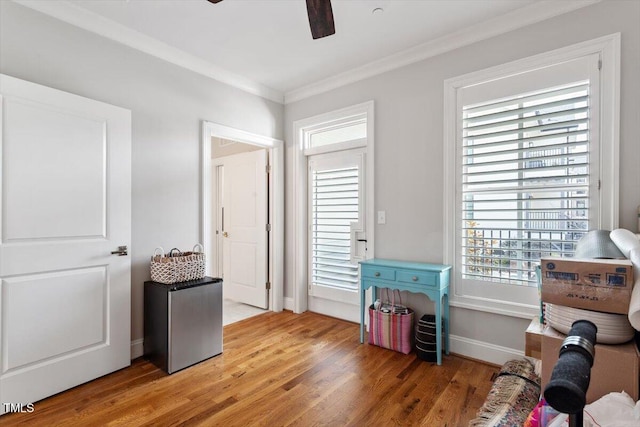 bedroom with ceiling fan, light wood-style floors, baseboards, and ornamental molding