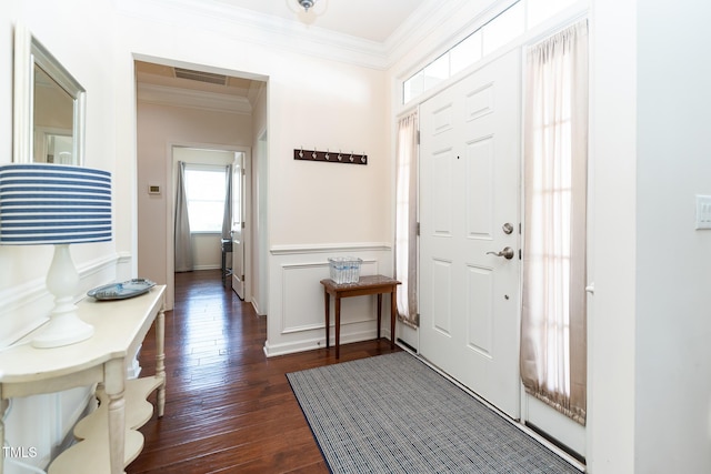 entryway with dark wood finished floors, visible vents, wainscoting, and ornamental molding