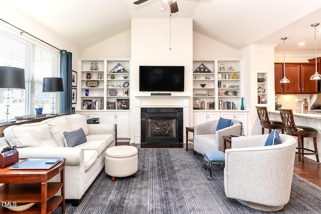 living area featuring dark wood finished floors, a fireplace with flush hearth, a ceiling fan, and vaulted ceiling