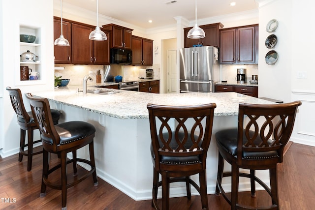 kitchen with a peninsula, stainless steel appliances, dark wood-type flooring, and a sink