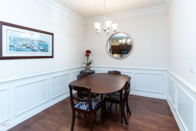 dining area with a decorative wall, a notable chandelier, crown molding, and dark wood-style flooring